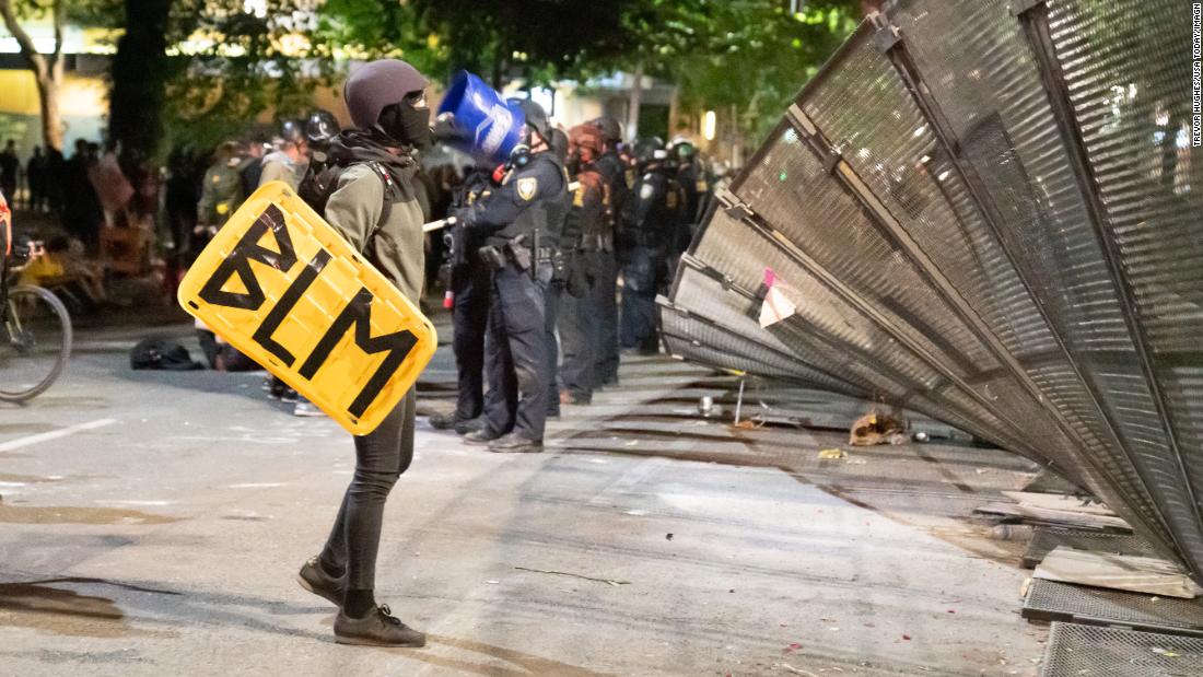 A protester inspects a torn-down fence outside the federal courthouse on July 26.