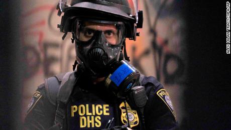 A federal officer monitors the scene outside the federal courthouse in Portland, Ore., on July 25, 2020. 