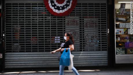 People walk by stores, many closed,  along River Avenue near Yankee Stadium on July 23, 2020 in the Bronx borough of New York City. Yankee stadium, which is closed to fans due to COVID-19 and social distancing restrictions, was a magnet for traffic to businesses in the area surrounding the famed stadium and many now stand closed or operate on restricted hours. The area of the South Bronx adjacent to the stadium has an unemployment rate of over 21 percent and is one of the country&#39;s poorest congressional districts. Major League Baseball will start up tonight to stadiums empty of fans.  (Photo by Spencer Platt/Getty Images)