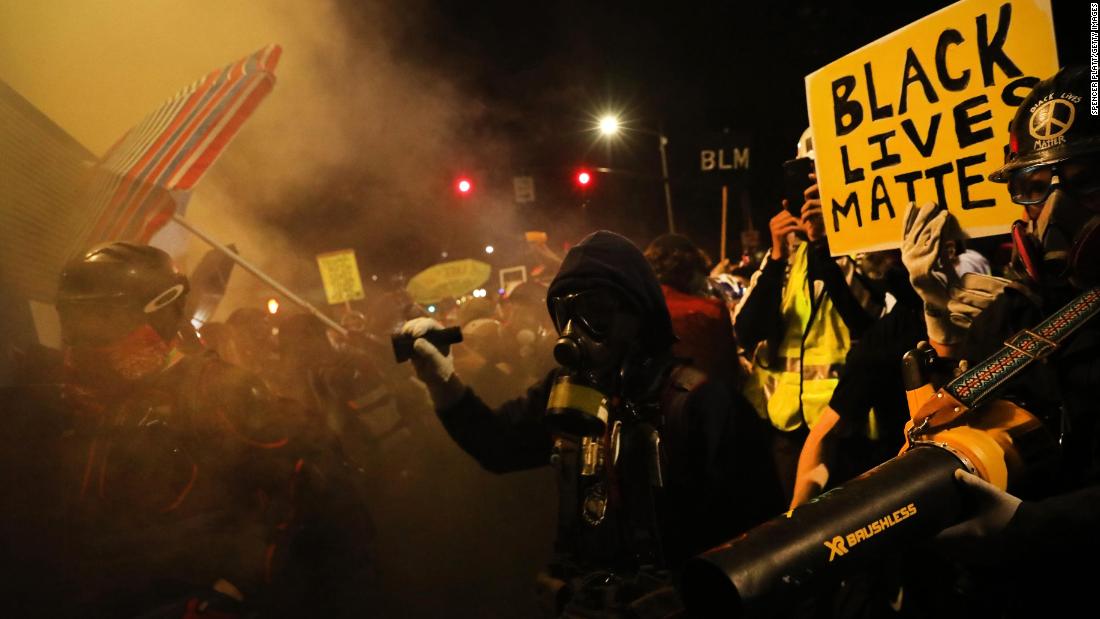 Protesters gather in a street filled with tear gas on July 25.