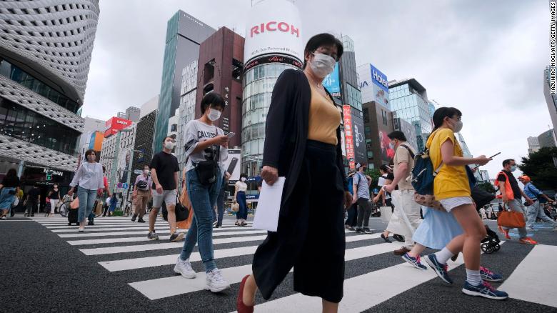 Pedestrians walk at a crossing in Tokyo&#39;s shopping district of Ginza on July 25, 2020. 