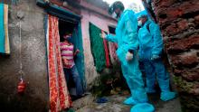 A healthcare worker wearing checks the temperature of a resident during a medical check-up at a slum in Mumbai, India on July 20, 2020. 