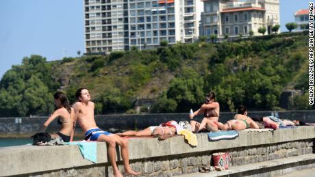 People sunbathe at the Cote des Basques beach in Biarritz, southwestern France, on July 30, 2020. 