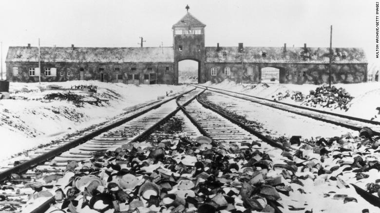 Snow-covered personal effects of those deported to the Auschwitz concentration camp litter the train tracks leading to the camp&#39;s entrance, in an image from around 1945. 