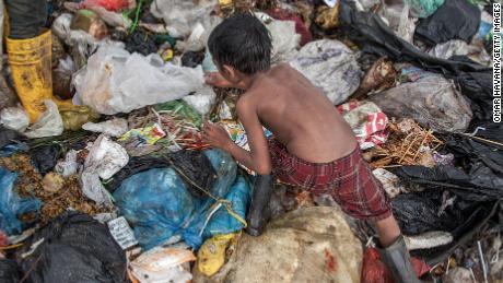 Growing up amid violence or poverty can be linked to accelerated aging, a new review of studies shows. A young boy searches for plastic in the Anlong Pi landfill in Siem Reap, Cambodia.