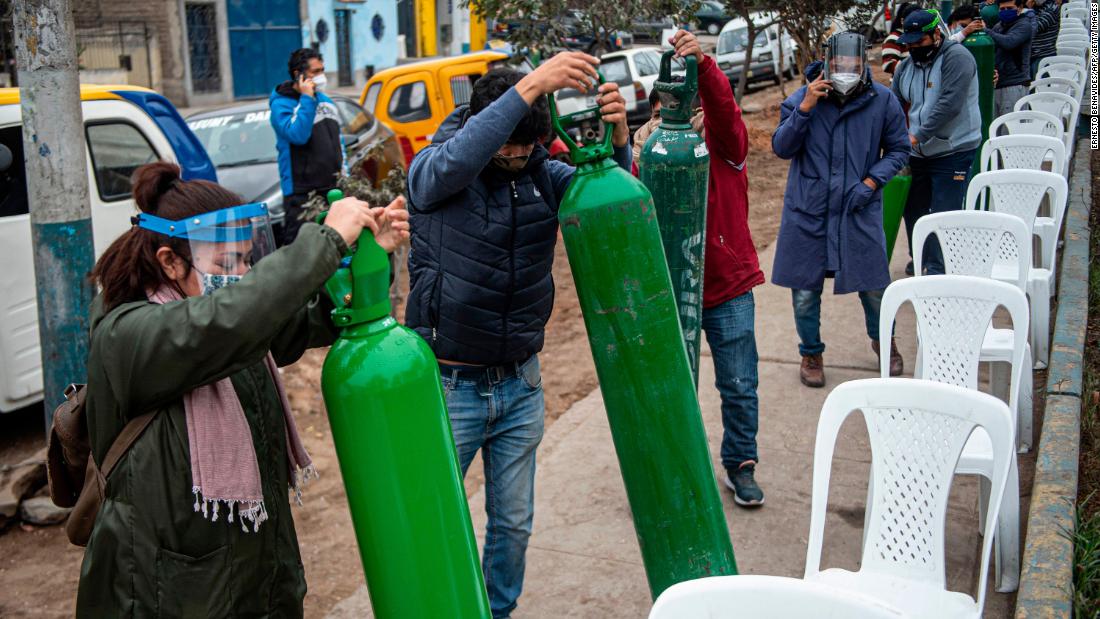 Relatives of Covid-19 patients line up to recharge oxygen cylinders in Villa Maria del Triunfo, Peru, on July 29.