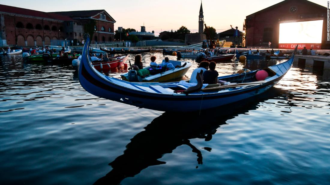 People watch the film &quot;The Prestige&quot; from a gondola boat in Venice, Italy, on July 28. Around the world, many films are being shown outside so that people can practice social distancing.