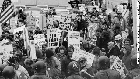 Los manifestantes llevan carteles contra autobuses escolares forzados frente a una reunión de líderes demócratas en Louisville, Kentucky, el 23 de noviembre de 1975.