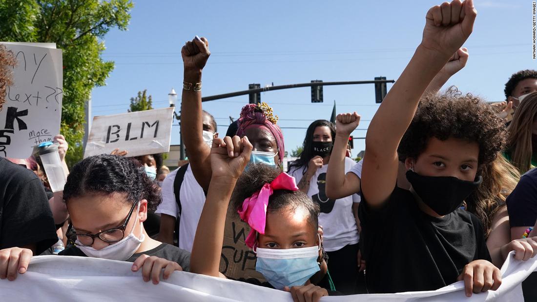 Protesters hold their fists in the air during a march on August 1.