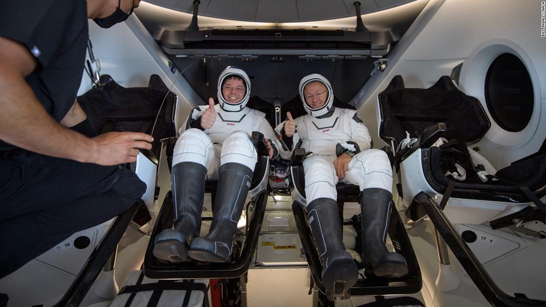 Behnken and Hurley give a thumbs-up before being extracted from the Crew Dragon spacecraft.