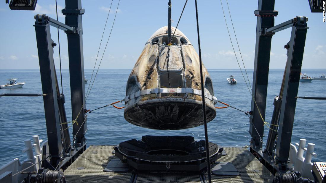 The Crew Dragon spacecraft is lifted onto a recovery ship shortly after splashdown.