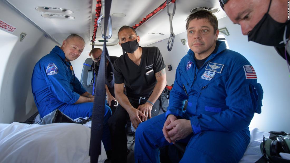 Hurley, left, and Behnken, second from right, ride in a helicopter after returning from space.