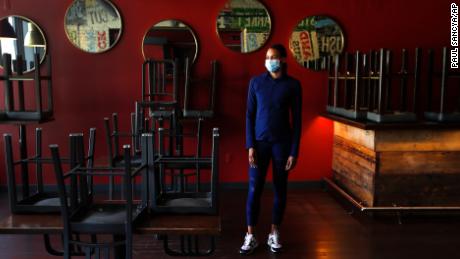 Stephanie Byrd, co-owner of The Block, poses for a photo with chairs on the tables while the restaurant is closed due to the coronavirus in Detroit on May 21, 2020.