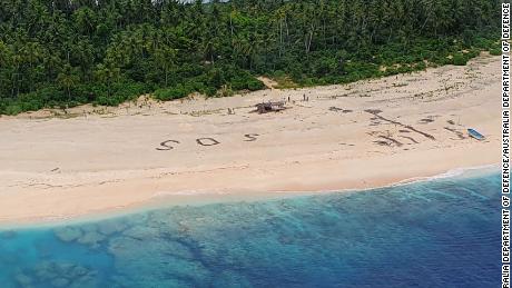 Three men from the Federated States of Micronesia on the beach of Pikelot Island, found after a combined US and Australian Search.Their SOS message outlined on a beach was spotted from the air by Australian and US aircraft searching the area.