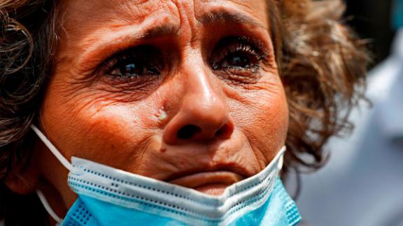 A woman, whose son was said to be missing after the explosion, waits outside Beirut's port to receive information from rescue teams.