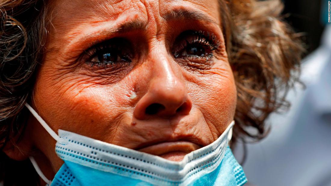 A woman, whose son was said to be missing after the explosion, waits outside Beirut&#39;s port to receive information from rescue teams.