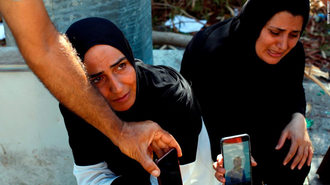 A woman and her sister-in-law show a photo of a missing man on August 7, 2020. Many people were reported missing after the explosion.