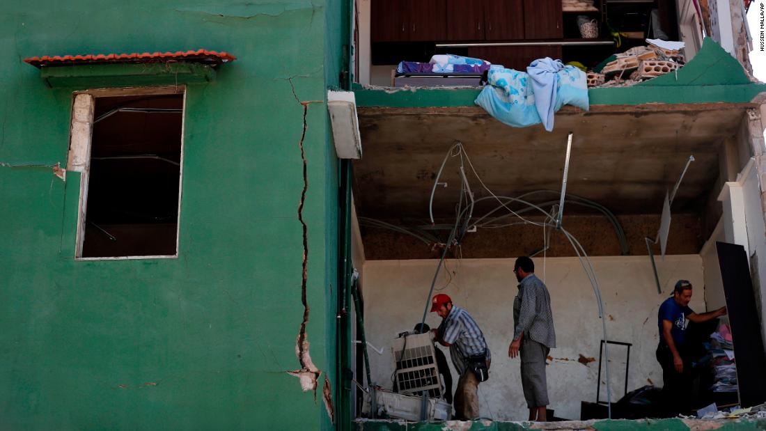 People remove debris from a house on August 7, 2020.