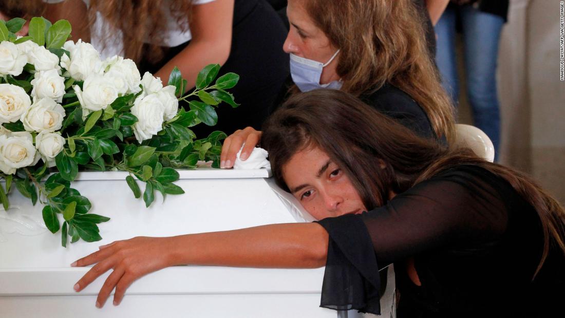 Christelle Helou hugs the coffin of her cousin Nicole in Sarba, Lebanon, on August 6, 2020.