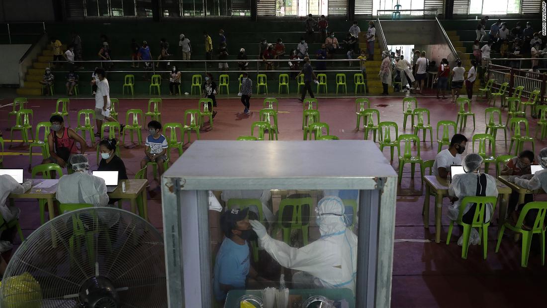 A health worker performs a Covid-19 test at a gymnasium in Navotas, Philippines, on August 6.