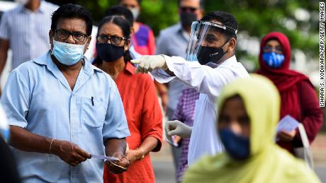 Sri Lankan voters cast their ballots with masks and face shields as parliamentary elections went on during the coronavirus pandemic. 