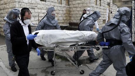 Workers at Chevra Kadisha, Israel&#39;s religious burial society, carry the body of a patient who died from complications of Covid-19 at the Shamgar Funeral Home in Jerusalem on April 1.