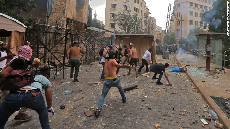 Lebanese protesters hurl rocks towards security forces.