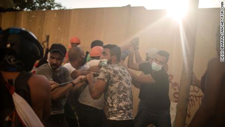 Protesters try to pull down a wall to get inside Parliament.