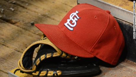 ST LOUIS, MO - MAY 12:  A detailed view of a St. Louis Cardinals baseball hat and glove sitting in the dugout during the game against the Chicago Cubs at Busch Stadium on May 12, 2014 in St Louis, Missouri. The Cubs defeated the Cardinals 17-5.  (Photo by Mark Cunningham/MLB Photos via Getty Images)