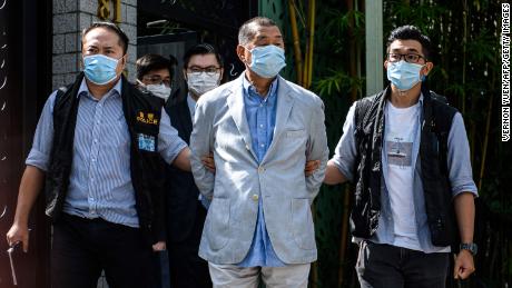 Police lead Hong kong pro-democracy media mogul Jimmy Lai (C), 72, away from his home after he was arrested under the new national security law in Hong kong on August 10, 2020. - Hong Kong pro-democracy media mogul Jimmy Lai was arrested under a new national security law on August 10 and police raided his newspaper offices in a deepening crackdown on dissent in the restless Chinese city.