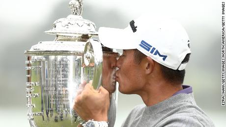 Morikawa celebrates by kissing the Wanamaker Trophy after winning the 2020 PGA Championship.