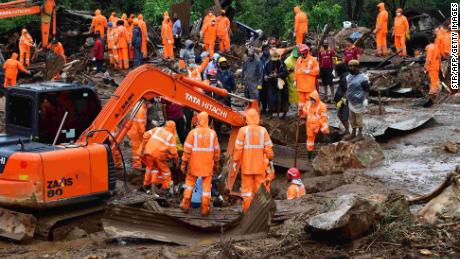 Rescue workers search for missing people at a landslide site caused by heavy rains in Pettimudy, in Kerala state, on August 8, 2020. 