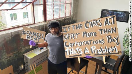 Furloughed airport bartender Robert Davis, 51, stands in his downtown Atlanta apartment on Aug. 10, 2020 with protest signs he's planning to use at a protest in support of the HEROES Act.