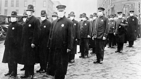 Police officers in Seattle wearing masks made by the Red Cross during the influenza epidemic in December 1918.