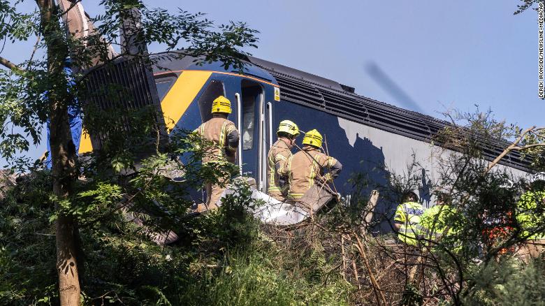 Emergency services attend the scene of a derailed train in Stonehaven, Scotland.