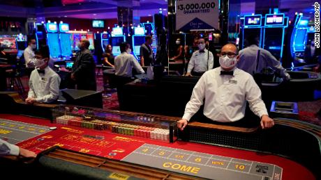 Los comerciantes con máscaras esperan a los clientes antes de que vuelva a abrir el D Las Vegas Hotel and Casino. 