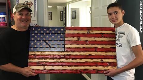 Lorenzo Liberti, 15, with a wooden flag he carved and painted.
