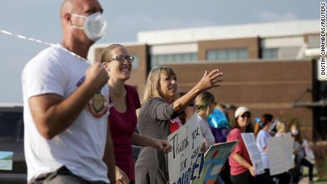 Supporters of the Cherokee County School District&#39;s decision to reopen schools cheer on faculty arriving to the district&#39;s headquarters in Canton, Georgia. 