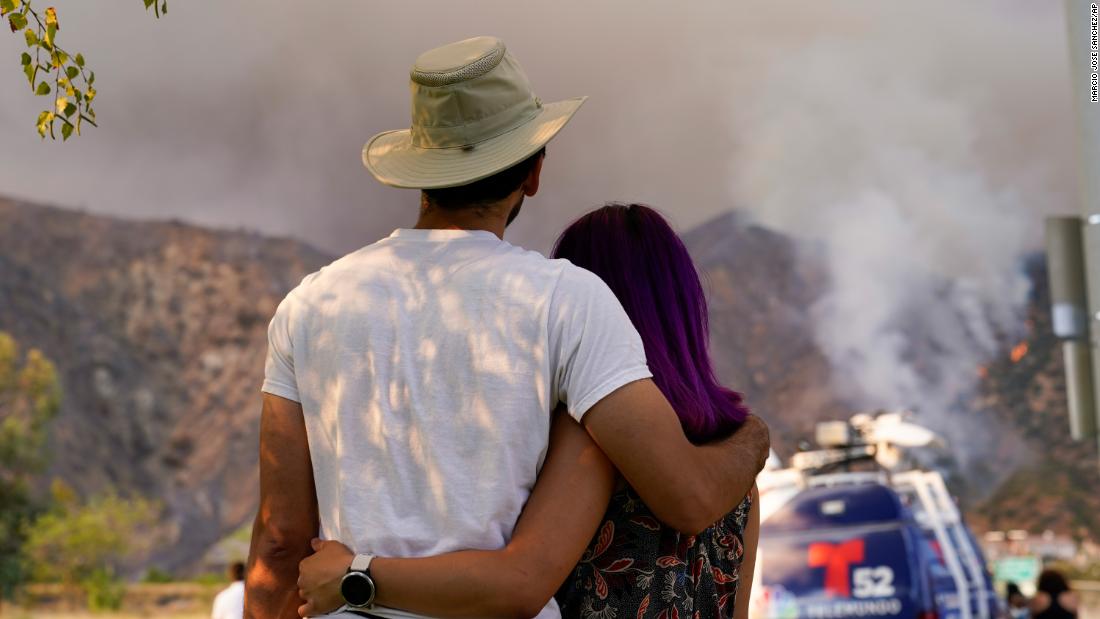 A couple watches the Ranch2 Fire from a distance on August 13, 2020.