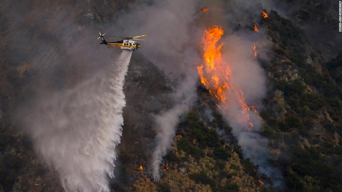 A helicopter makes a water drop over the Ranch2 Fire in Azusa, California, on August 13, 2020.