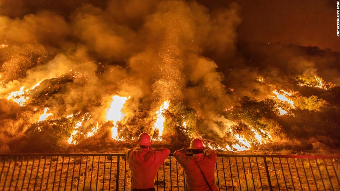 Firefighters look at smoke and flames rising from the Ranch2 Fire in the San Gabriel Mountains, east of Los Angeles, on August 14, 2020.