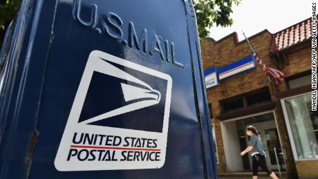 Postal service backs down on changes as at least 20 states sue over potential mail delays ahead of election