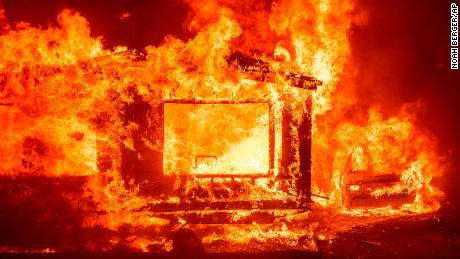 A mobile home and car burn Tuesday at Spanish Flat Mobile Villa as the LNU Complex fires tear through unincorporated Napa County, California. 