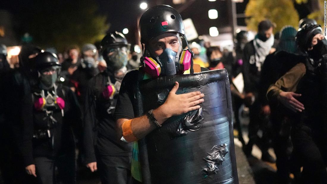 A protester slaps his shield while marching toward the Portland Police Bureau&#39;s North Precinct on August 10.