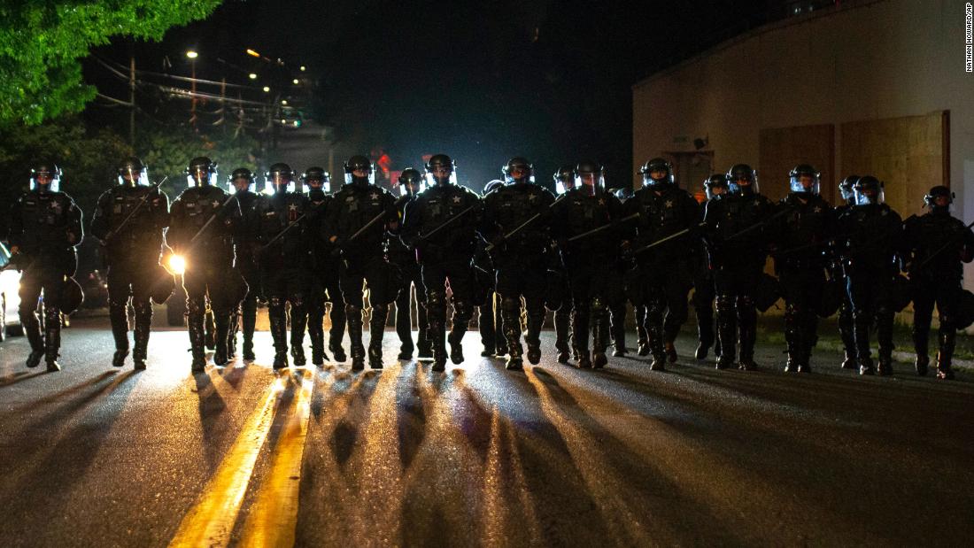 Portland police officers walk through the Laurelhurst neighborhood after dispersing a protest of about 200 people on August 8.