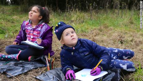 (From left) Roxinny Parra Salgado and Tilly Harris-Taylor observe, listen to and document the sights and sounds of the wetland environment of the Tualatin River outside of Cornelius, Oregon, as part of the curriculum at the Early Learning Community School at Pacific University.