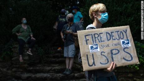 TOPSHOT - A group of protestors hold a demonstration in front of Postmaster General Louis DeJoy's home in Greensboro, North Carolina on August 16, 2020. - DeJoy has recently come under fire for what's perceived as steps ordered by the Trump administration to slow down the United States Postal Service to help suppress absentee votes. (Photo by Logan Cyrus / AFP) (Photo by LOGAN CYRUS/AFP via Getty Images)