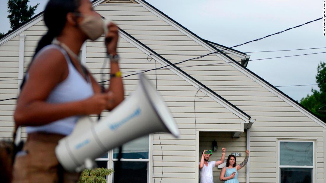 People watch a protest pass by on August 20.