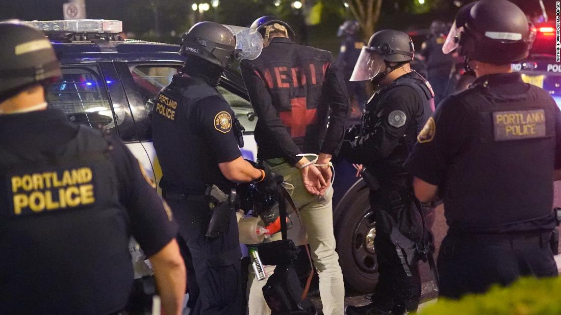 Portland police officers arrest a man said to be a street medic during a dispersal outside the Immigration and Customs Enforcement (ICE) detention facility on August 21.