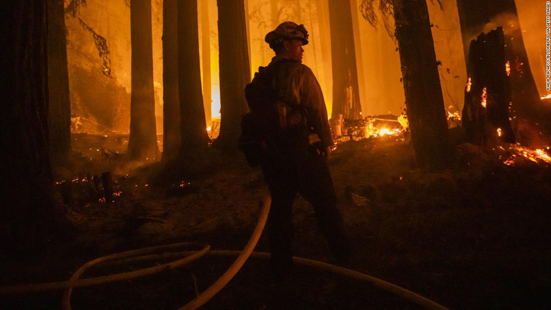 A firefighter battles flames in Santa Cruz County, California, on August 20, 2020.